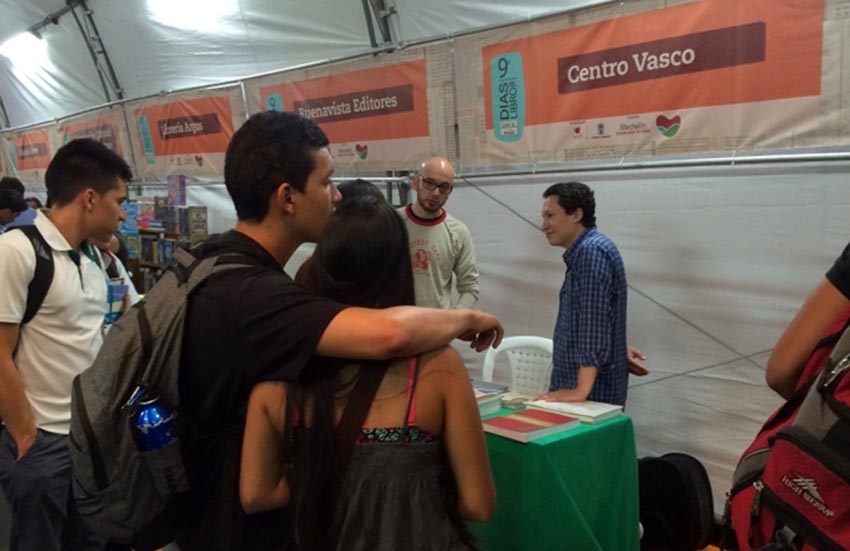 Aspecto del stand de Gure Mendietakoak en la feria Días del Libro de Medellín, atendida por John Ricaurte (con camisa zul de cuadros).