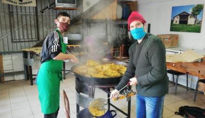 La nueva generación de sukaldaris del Centro nicoleño a cargo de las paellas, con barbijo y manteniendo la distancia