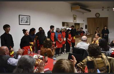 Los estudiantes de cocina, realizadores de la Cena Aniversario de Itxaropen de Saladillo, reciben el aplauso de los comensales 