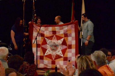 Miembros de Oinkari y el alcalde de Iurreta (en el centro) muestran la bandera de Iurreta especialmente bordada para Boise con que cuentan desde ahora los dantzaris boiseanos para ocasiones especiales de bailar Dantzari-dantza.