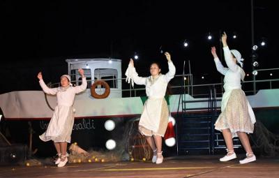 Dantzaris de Trenque Lauquen bailando frente al barco en el espectáculo 'Inmigrante'