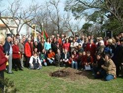 Foto de familia de parte de los asistentes  frente al nuevo retoño de la Plaza Gernika de Montevideo