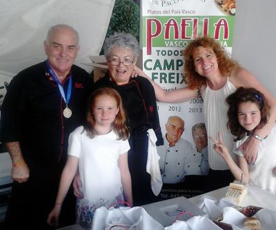 Paco Casteig y Bego Illarramendi acompañados de una amiga, Eva, y sus hijas Carlota y Natalia, frente a un cartel de su restaurante